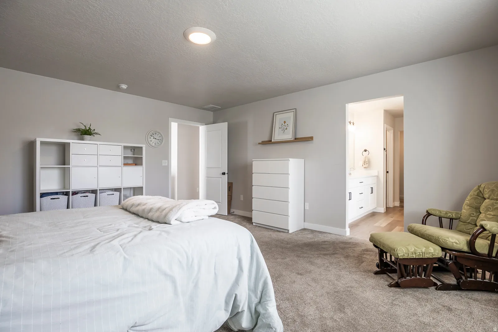 Recessed ceiling light, neutral wall paint, carpet flooring, entryway to bathroom, vanity with base cabinetry