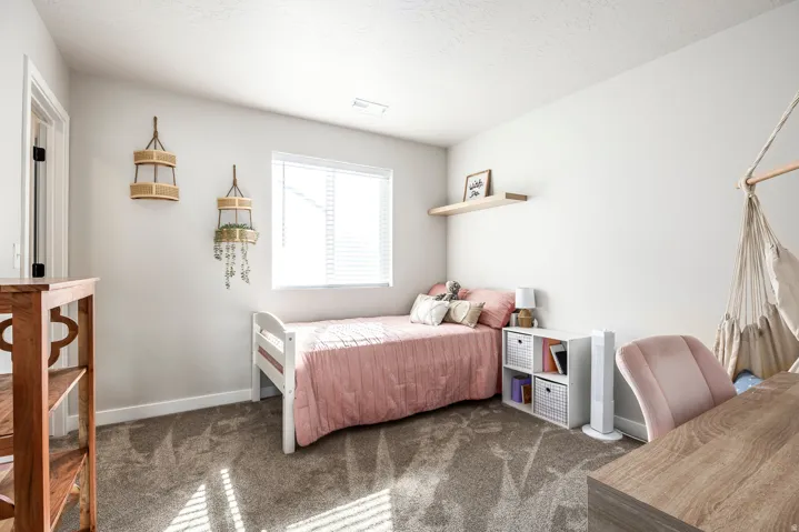 White walls with textured ceilings, light gray carpet, and a window with blinds