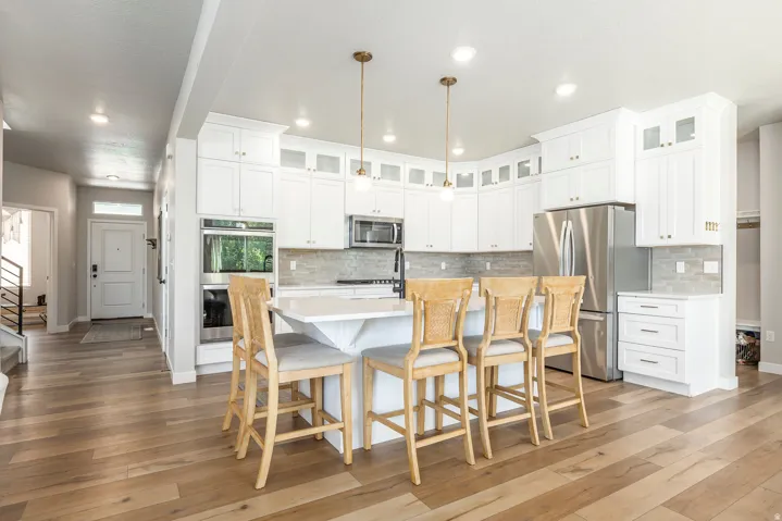 Contemporary kitchen featuring a large island, stainless steel double ovens, and a matching refrigerator