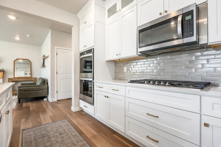 Modern kitchen featuring white cabinetry, stainless steel appliances, a gas range, white countertops, and a subway tile backsplash