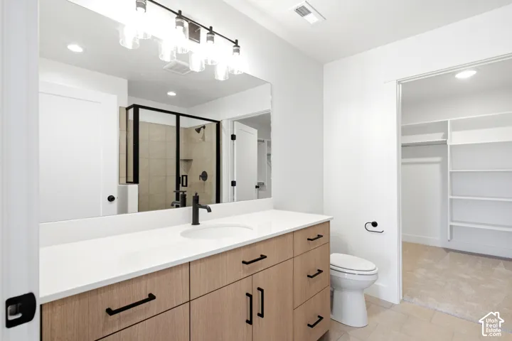 Bathroom featuring a wood-finish double vanity with a light-colored countertop, an undermount sink, and black fixtures