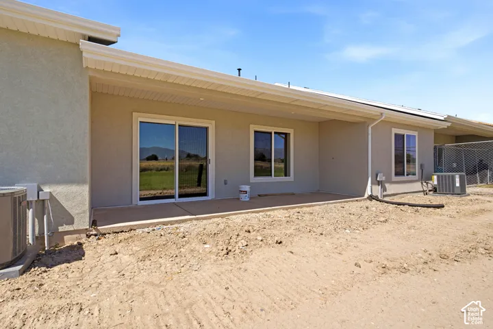 Exterior featuring a covered patio, stucco siding, and sliding glass doors