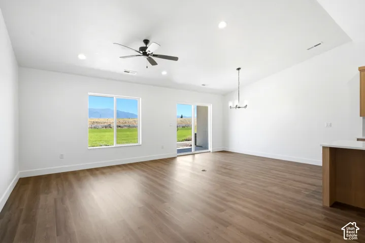 Spacious living area featuring wood-finish flooring, a ceiling fan, recessed lighting, and a sliding glass door