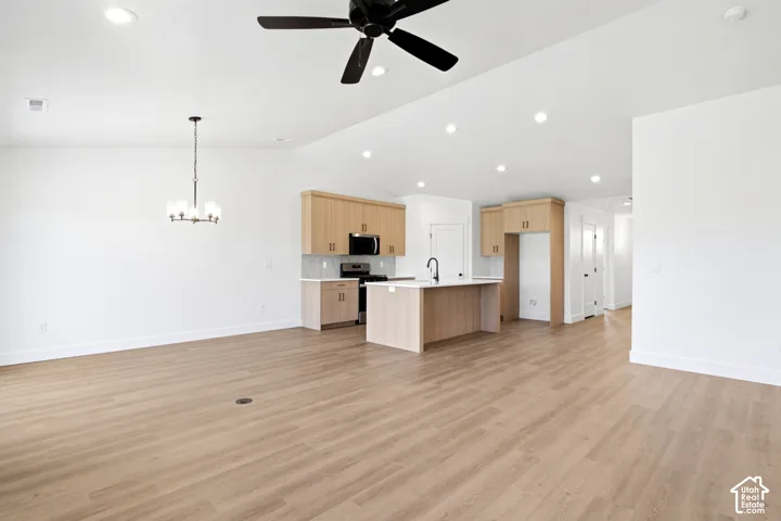Open-concept living space featuring wood-finish flooring, recessed lighting, and a modern ceiling fan