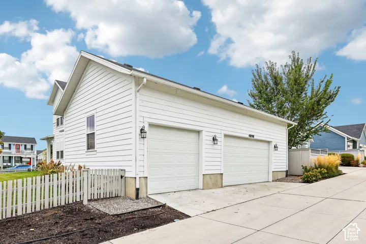 3 car garage with white panel doors and exterior sconces