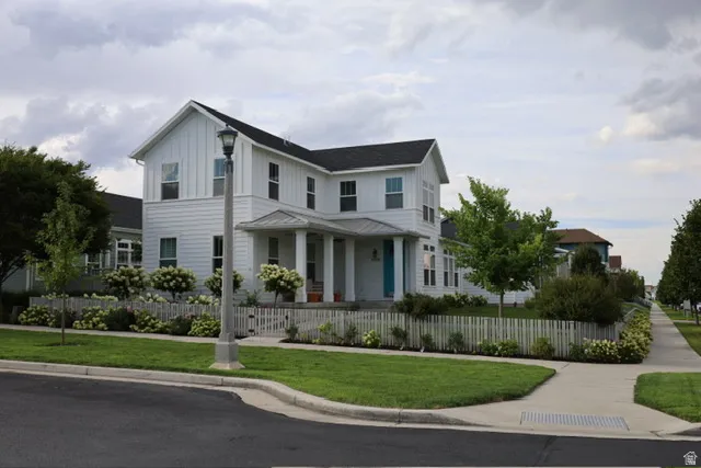 Classic white board-and-batten exterior with a contrasting dark roof for timeless curb appeal.