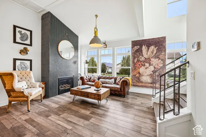 Easy care laminate flooring throughout, custom tiled fireplace with an integrated hearth, soaring vaulted ceilings, extensive window placement, and a staircase with a wrought iron railing