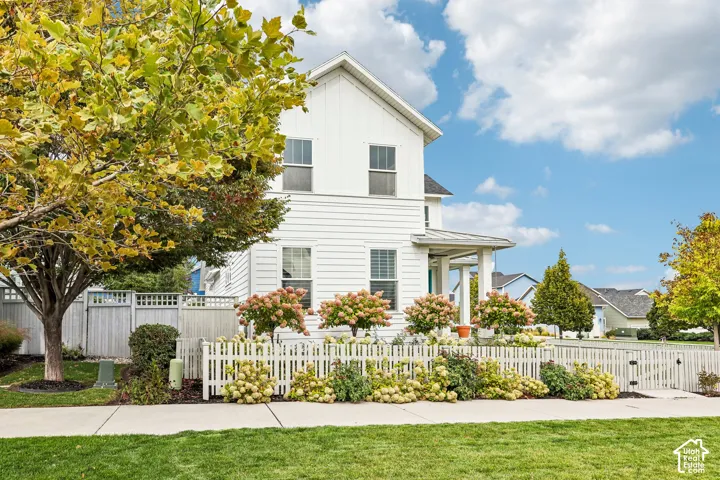 White siding exterior with a pitched roofline, featuring a covered front porch supported by columns