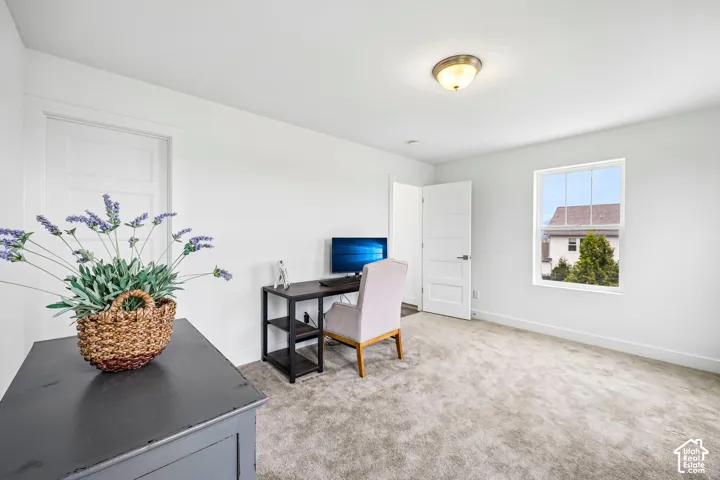 Another view of the 2nd bedroom that has a bright interior with a single window, white walls, light-colored carpeting, and a flush mount ceiling light fixture