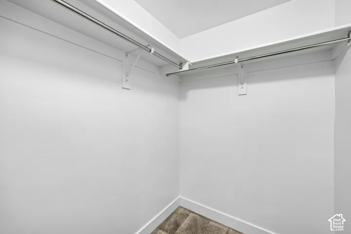 Walk-in closet with integrated shelving, chrome hanging rods, and neutral-toned wall finish