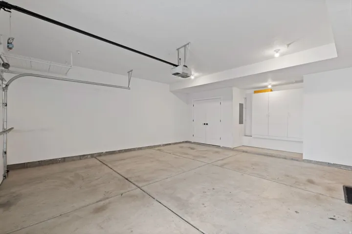 Concrete flooring, dual entry doors, built-in cabinetry, recessed lighting, and an overhead storage rack