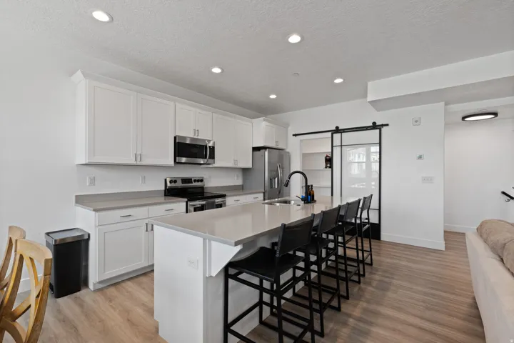 Modern kitchen with white cabinetry, stainless steel appliances, and a central island