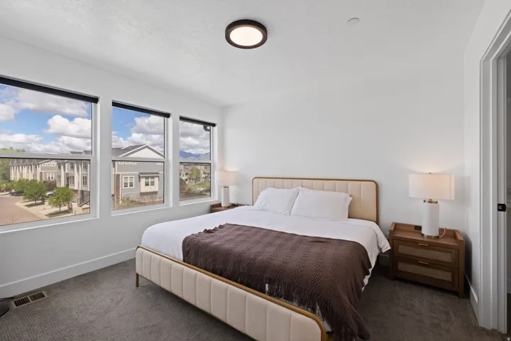 Three large windows, recessed ceiling light fixture, wall-to-wall carpeting, and white walls
