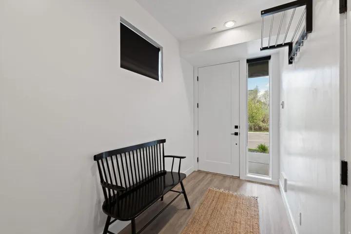 Entryway with wood-finish flooring, a full-lite entry door, a sidelite window, and a transom window