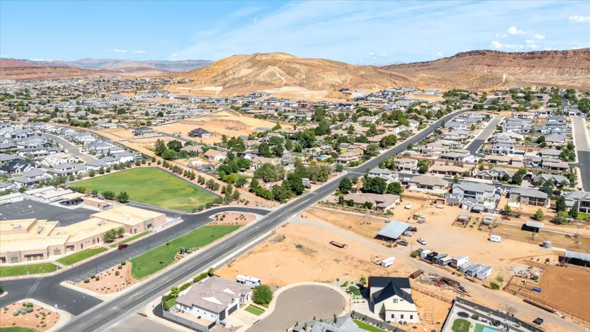 Expansive residential area with diverse architectural styles, surrounded by natural desert landscape and distant mountains