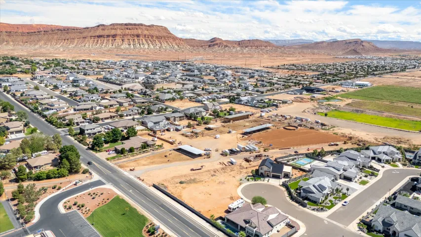 Expansive residential development featuring red rock formations and a mix of completed and developing properties