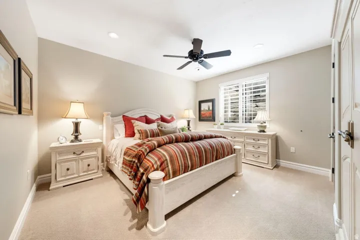 Recessed lighting, ceiling fan, carpet flooring, window with plantation shutters, and a paneled door