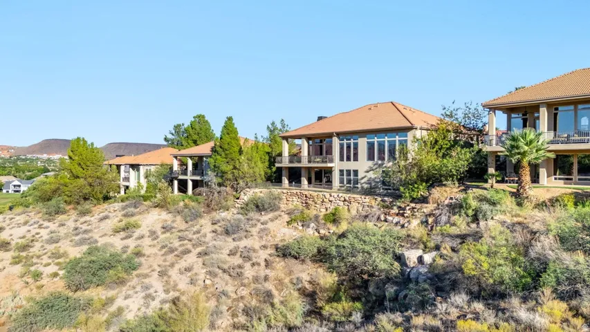 Southwestern-style architecture featuring a tile roof, stucco exterior, multiple balconies, and abundant windows