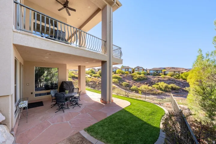 Terrace with flagstone paving and an upper-level balcony featuring metal railings