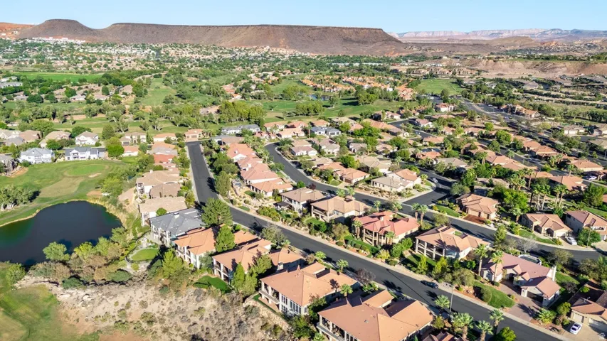 Expansive residential area with a golf course, pond, and mountainous backdrop