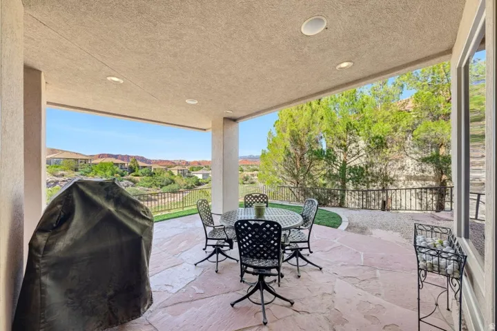Covered patio featuring a flagstone floor, recessed lighting, and a wrought iron style railing
