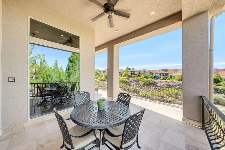 Covered outdoor patio with tile flooring and a ceiling fan