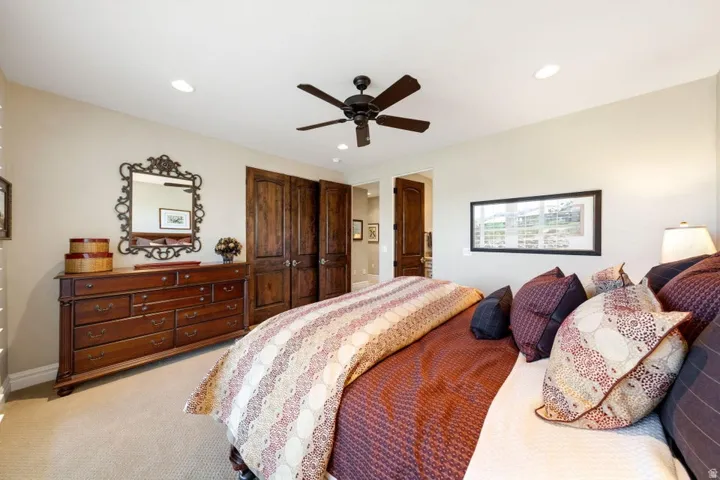 Recessed lighting, ceiling fan, carpet flooring, and wood-paneled doors