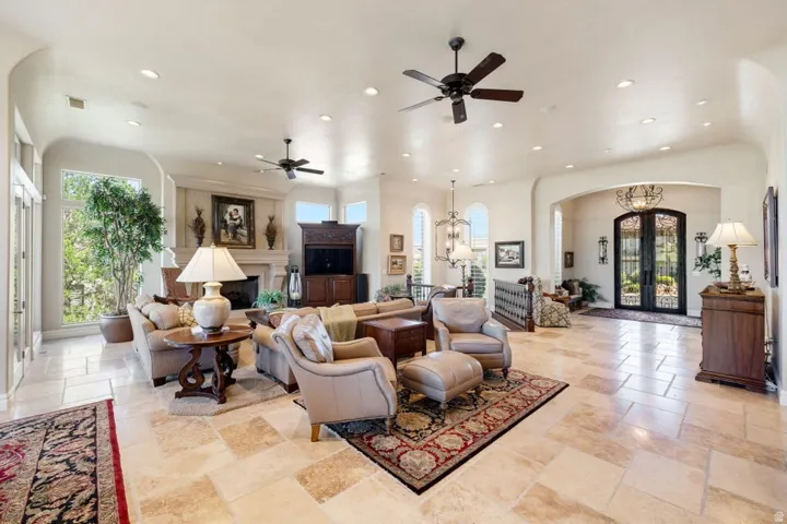 Expansive living area featuring recessed lighting, ceiling fans, and stone tile flooring