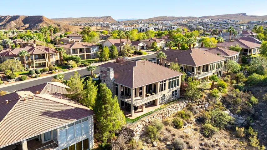 Residential property featuring a tile roof, stone chimney, and multiple balconies