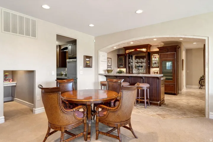 Built-in wet bar with wood cabinetry, integrated wine cooler, and recessed lighting