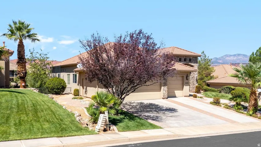 Stucco exterior with stone accents, tile roofing, and an integrated two-car garage
