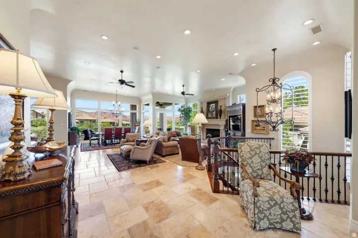 Expansive open-concept living area featuring large format tile flooring, recessed lighting, and a fireplace with a mantel