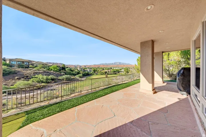 Covered patio featuring flagstone flooring, recessed lighting, and a metal railing