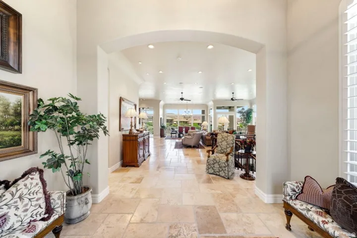 Archway entry leading to an expansive hall with tile flooring, recessed lighting, and a ceiling fan