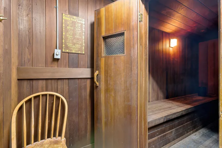 Wood-paneled room featuring a built-in sauna with wood bench seating