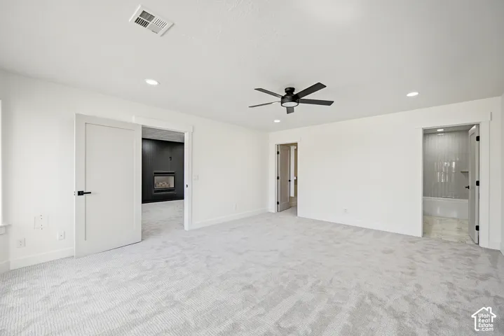 White walls with recessed lighting, ceiling fan, and carpeted flooring