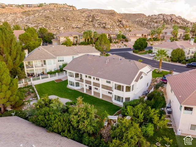 Multi-level residence featuring a terraced backyard, manicured lawn, and mature landscaping