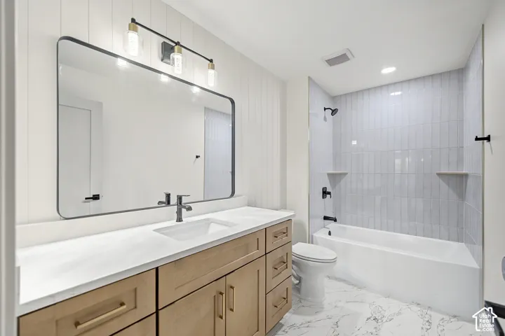 Vanity with light wood-finish cabinetry, white countertop, and integrated sink