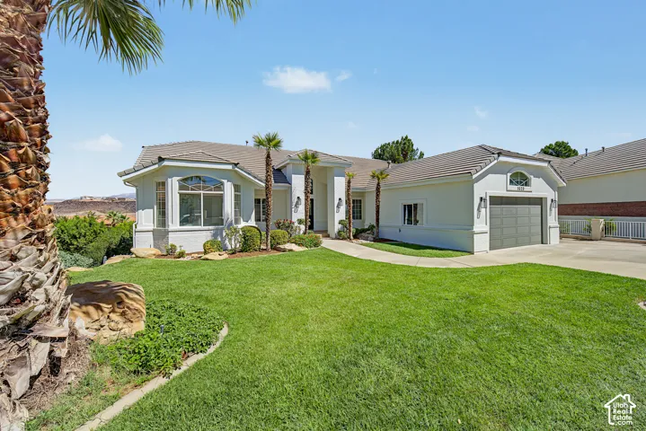 Stucco exterior residence with a tiled roof, bay window, and an attached two-car garage