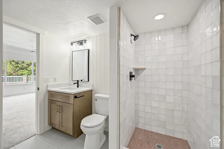 Walk-in shower with white square wall tiles and a dark-toned shower head
