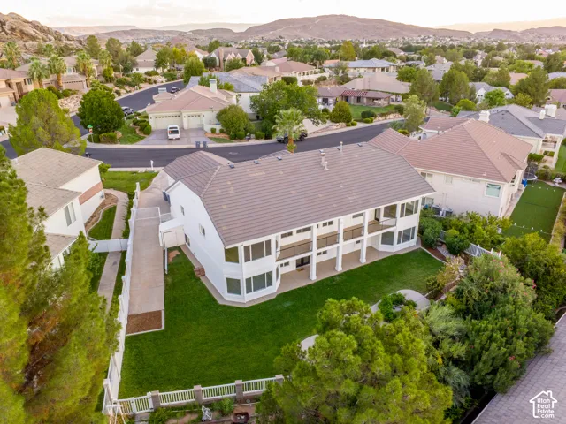Spacious property featuring a large backyard with a manicured lawn, an extended patio, and multiple balconies