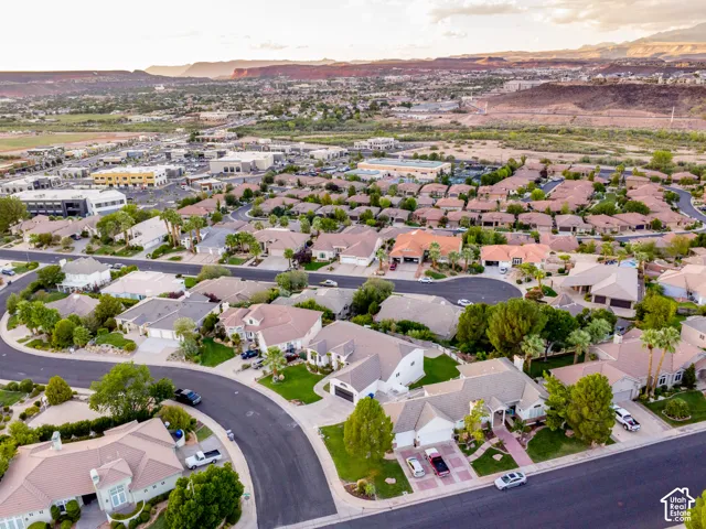 Residential neighborhood with curving streets, mature landscaping, varied rooflines, and distant mountain backdrops