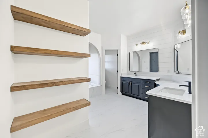Dual vanities with white countertops, black cabinetry, and black fixtures