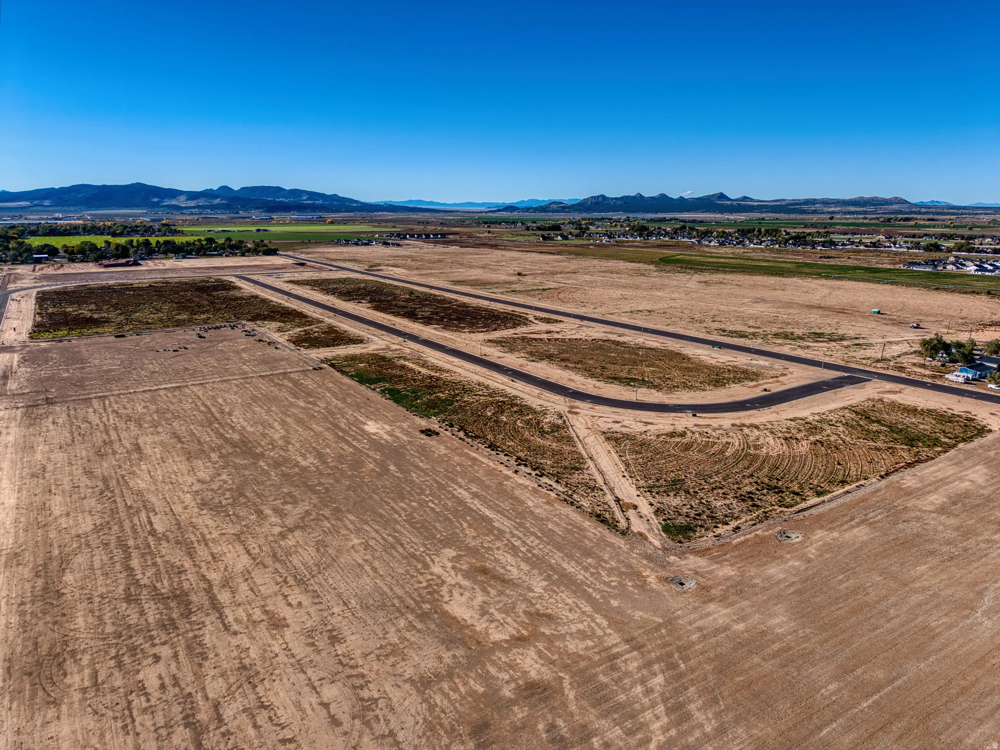 Expansive undeveloped land featuring graded sections and paved roadways