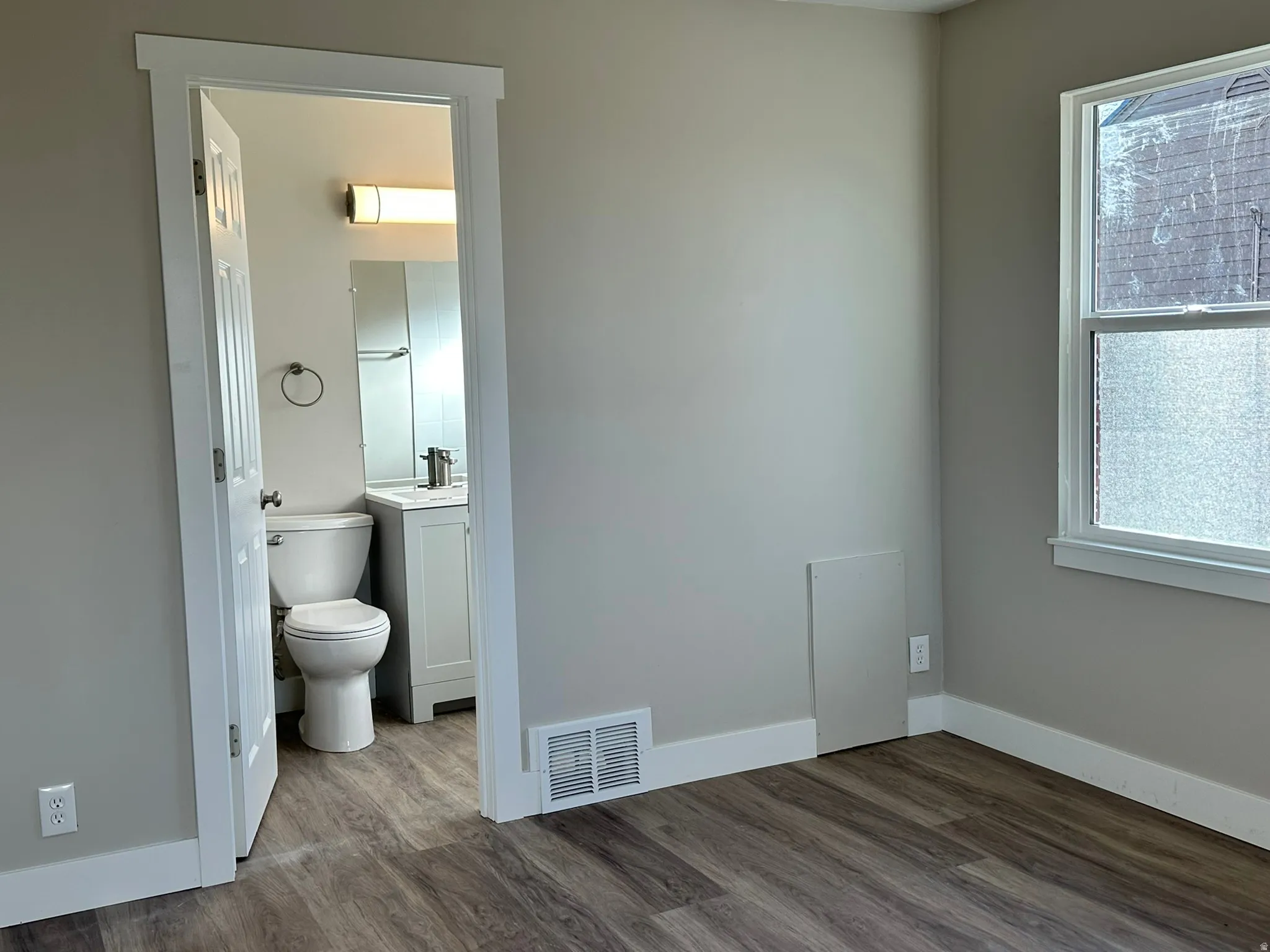 Wood-finish flooring throughout, bright white window trim, and neutral wall tones