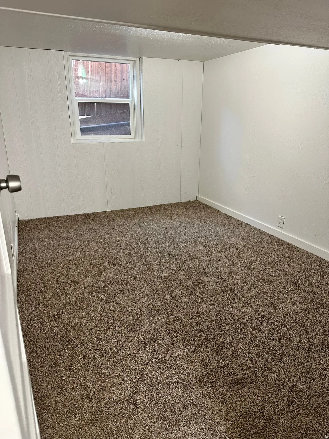 Neutral-toned carpeting in an interior space with a single window