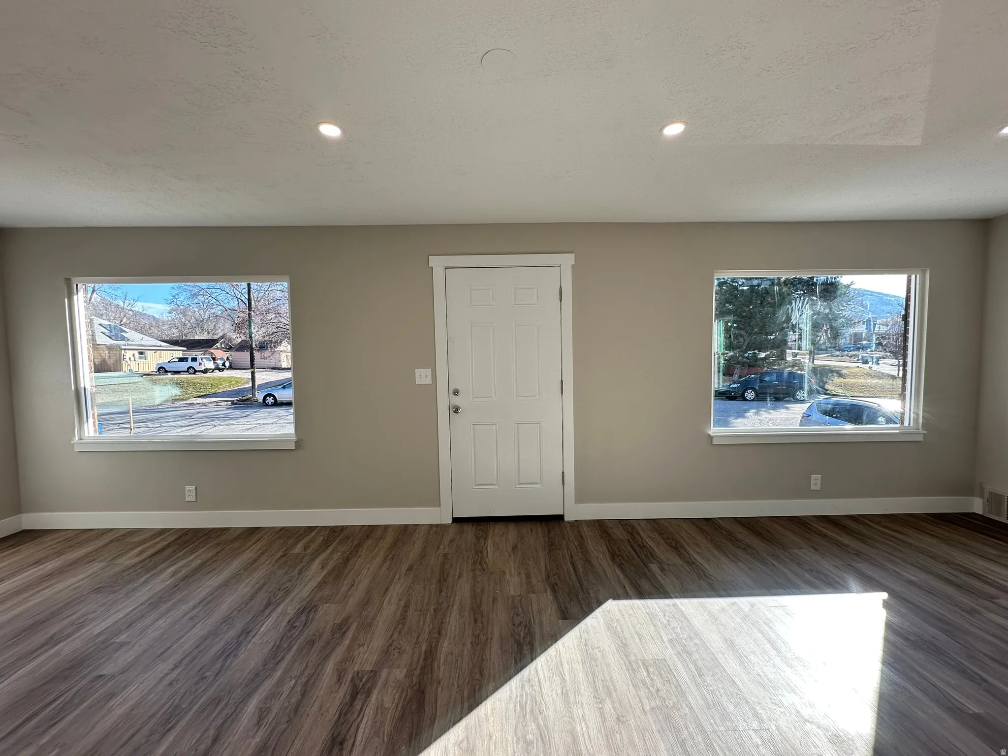 Wood-finish flooring throughout, complemented by recessed lighting and neutral wall tones