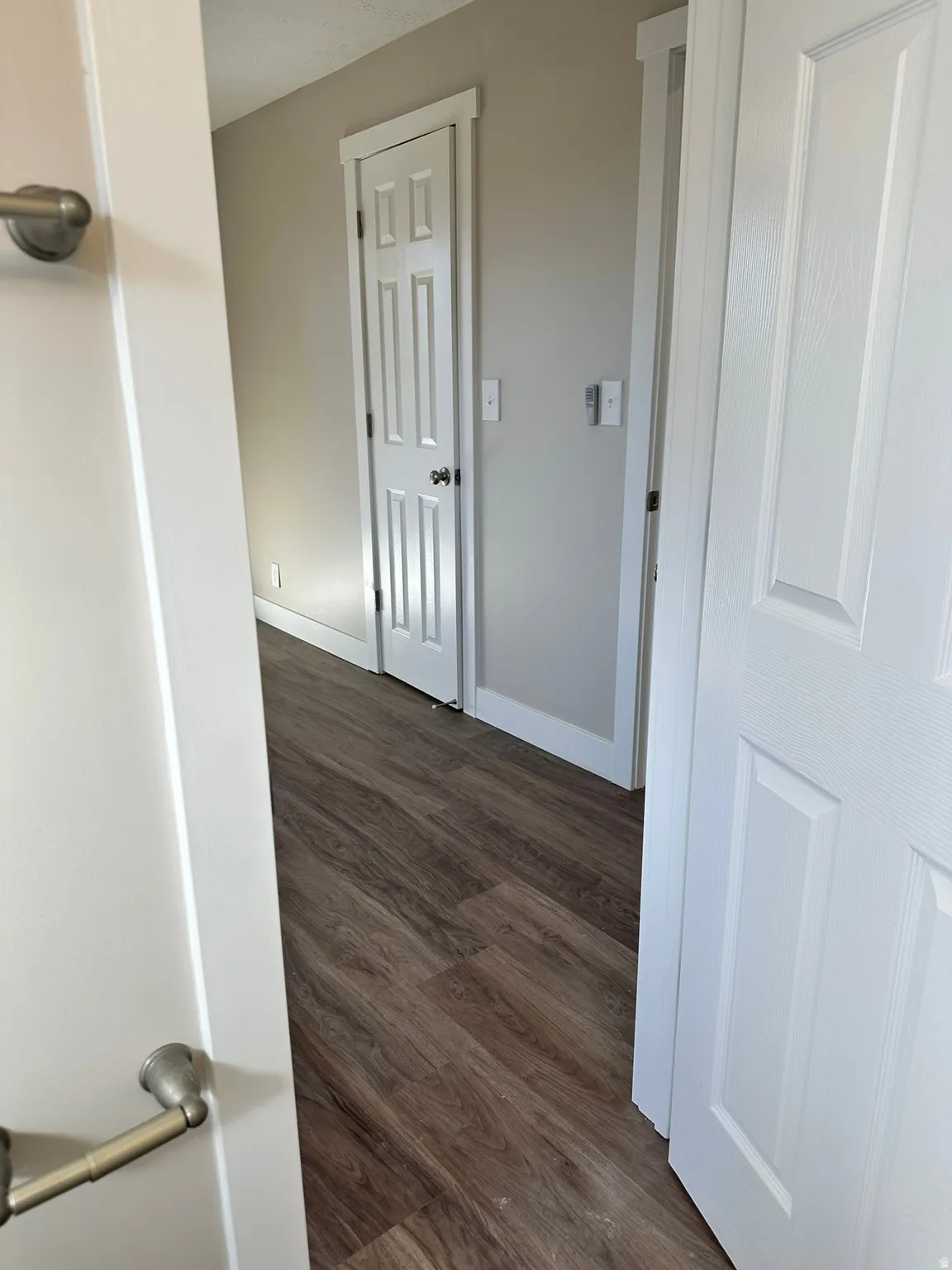 Wood-finish flooring throughout, complemented by light-toned wall paint and white trim details