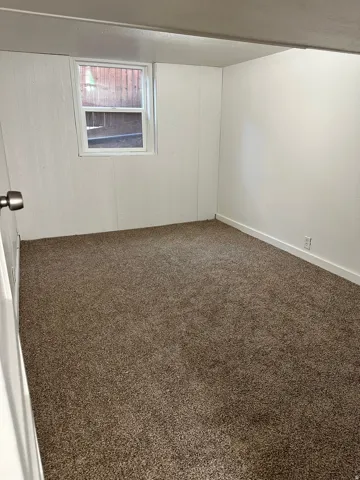 Neutral-toned carpeting in an interior space with a single window