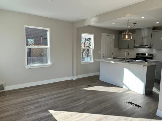 Open-concept living space featuring wood-finish flooring, recessed lighting, and a kitchen island with pendant lighting